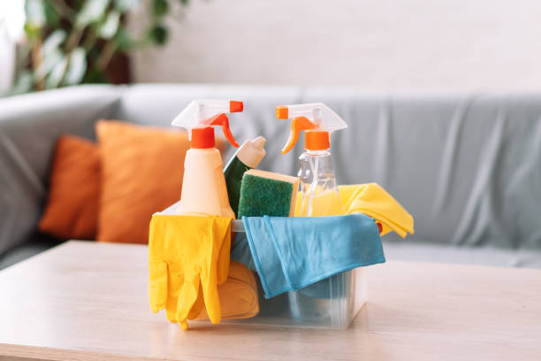 Cleaning products with rags and gloves lie in a plastic container. Cleaning products with rags and gloves lie in a plastic container.