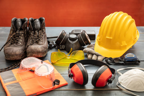 s4 Work safety protection equipment. Industrial protective gear on wooden table, red color background. Construction site health and safety concept